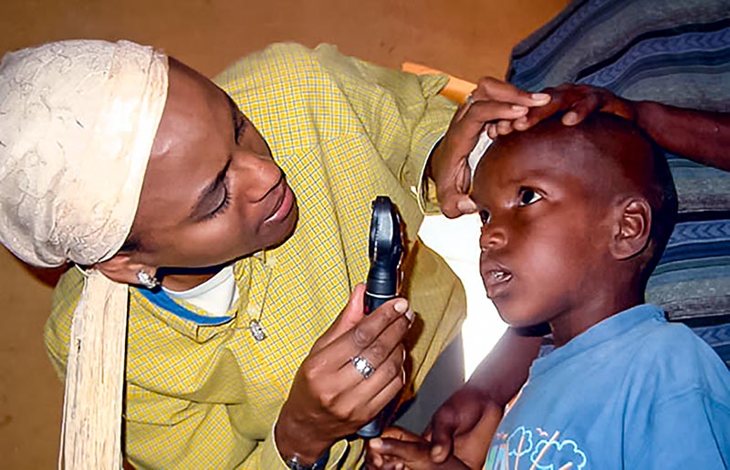 Ophthalmologist examine a child's eye with a handheld ophthalmoscope