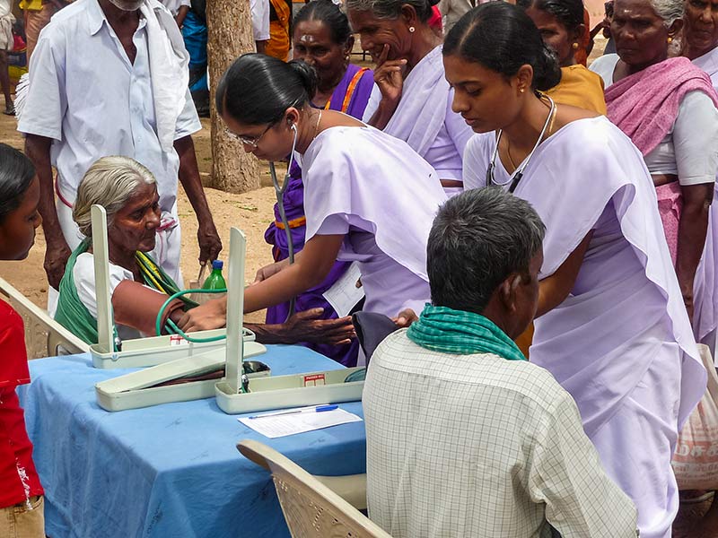 Female Indian ophthalmic nurses checking the blood pressure of patients using sphygmomanometers