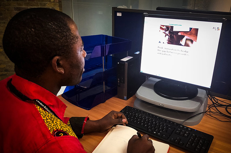 An African male student sitting at his desk, looking at the FutureLearn course on his computer monitor