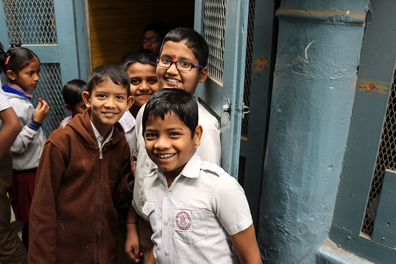 School children smiling outside a classroom