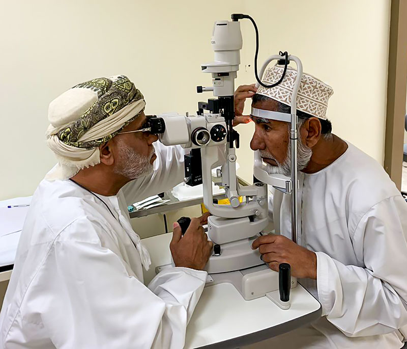 Optometrist & patient sitting at a slit-lamp