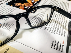 a pair of spectacles resting on top of a copy of the journal